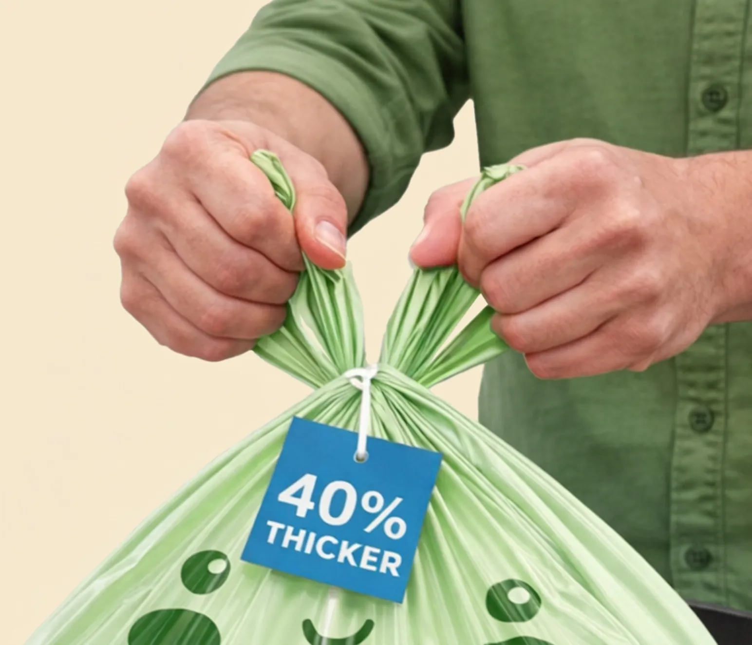 Hands tying the easy-tie handles of a GreenTuff compostable bag, with a 40% thicker tag